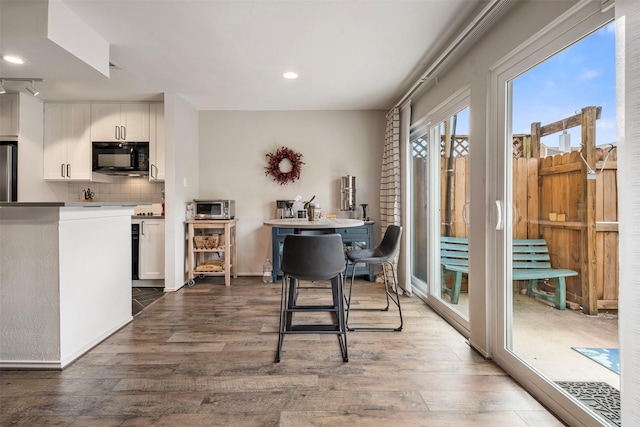 dining space with a toaster, wood finished floors, and recessed lighting