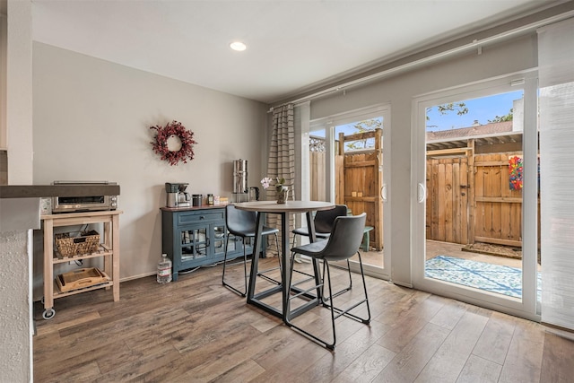 dining room with recessed lighting, baseboards, and wood finished floors