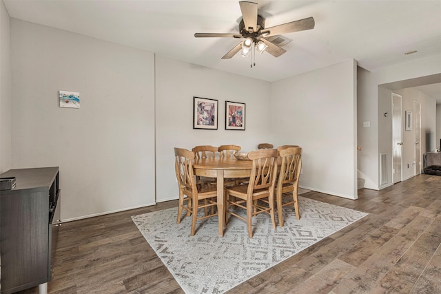 dining area with visible vents, dark wood finished floors, baseboards, and ceiling fan