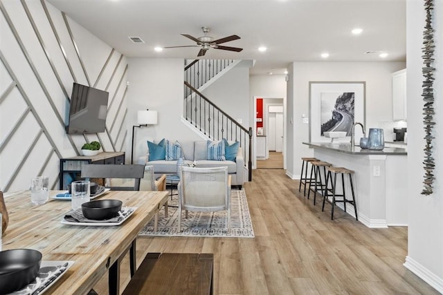 living area featuring recessed lighting, visible vents, light wood-style flooring, stairway, and a ceiling fan