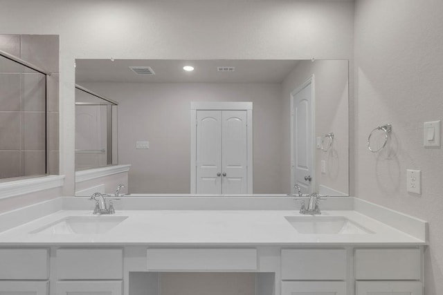 bathroom with visible vents, a sink, and double vanity