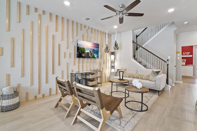 living area featuring light wood finished floors, baseboards, stairway, and recessed lighting