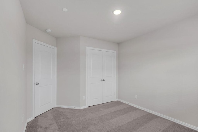 unfurnished bedroom featuring carpet, baseboards, a closet, and recessed lighting