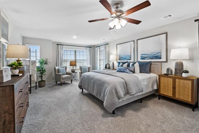 bedroom featuring light carpet, baseboards, visible vents, and ceiling fan