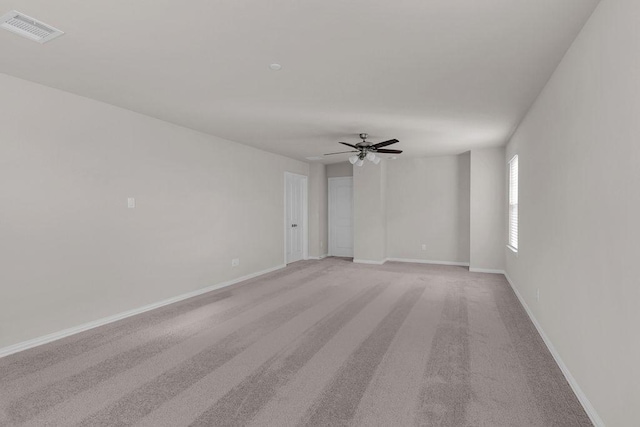 empty room with visible vents, ceiling fan, light carpet, and baseboards