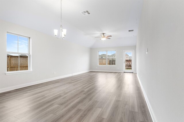 13324 Silver Egret Ln, Texas City, TX 77568 - unfurnished living room featuring ceiling fan with notable chandelier, light wood finished floors, visible vents, and baseboards