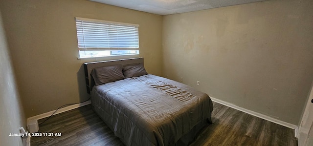 bedroom with wood finished floors and baseboards