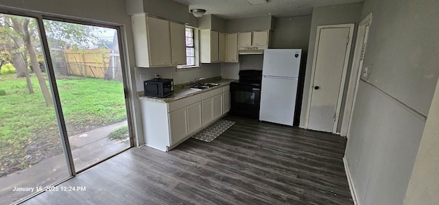 kitchen with black microwave, dark wood-style flooring, a sink, freestanding refrigerator, and electric range oven