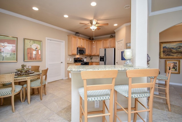 kitchen featuring ceiling fan, a peninsula, ornamental molding, appliances with stainless steel finishes, and backsplash