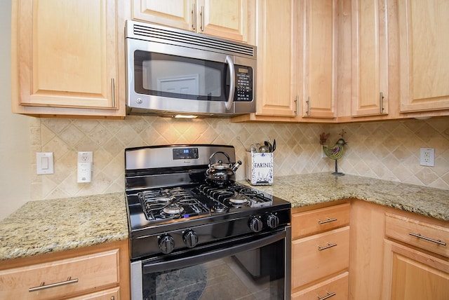 kitchen featuring light stone counters, decorative backsplash, light brown cabinetry, stainless steel microwave, and gas stove