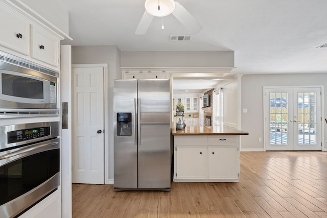 kitchen with white cabinetry, light wood-type flooring, and stainless steel appliances