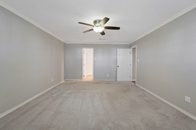 unfurnished room featuring light colored carpet, baseboards, a ceiling fan, and crown molding