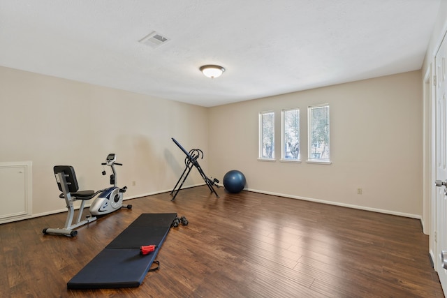 workout room with visible vents, baseboards, and wood finished floors