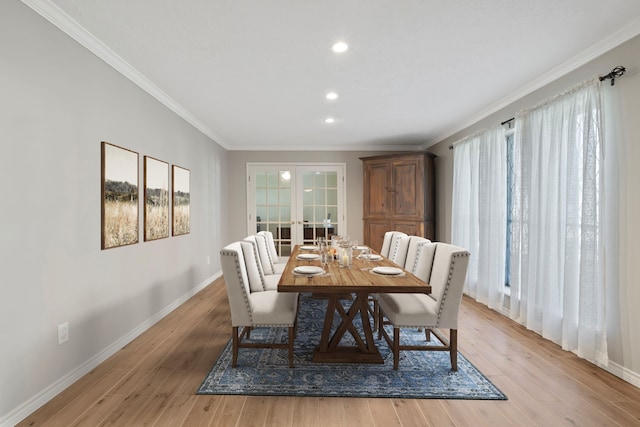 dining room with light wood-type flooring, french doors, and ornamental molding