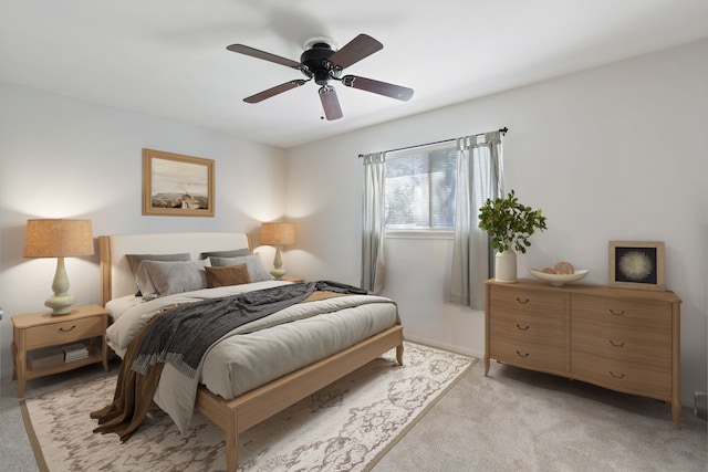 bedroom with light colored carpet and a ceiling fan