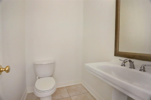 bathroom with baseboards, a sink, toilet, and tile patterned floors