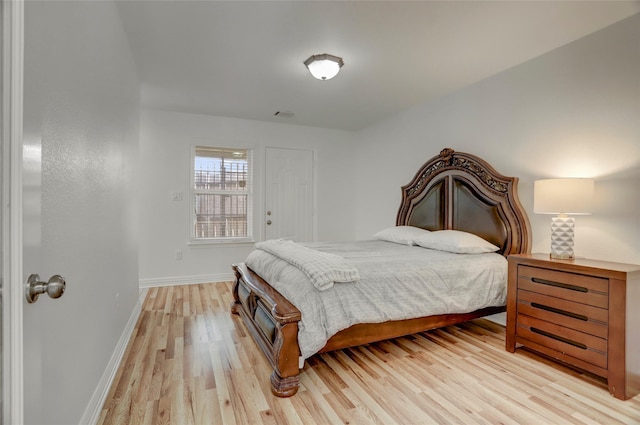 bedroom featuring light wood-type flooring, visible vents, and baseboards