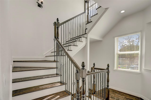 staircase featuring recessed lighting, vaulted ceiling, baseboards, and wood finished floors