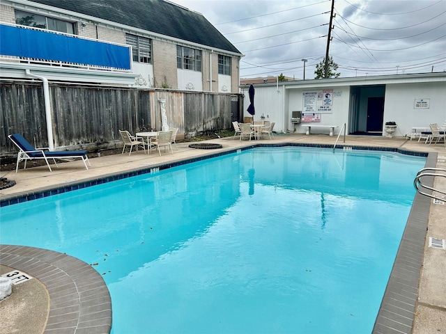 pool featuring fence and a patio