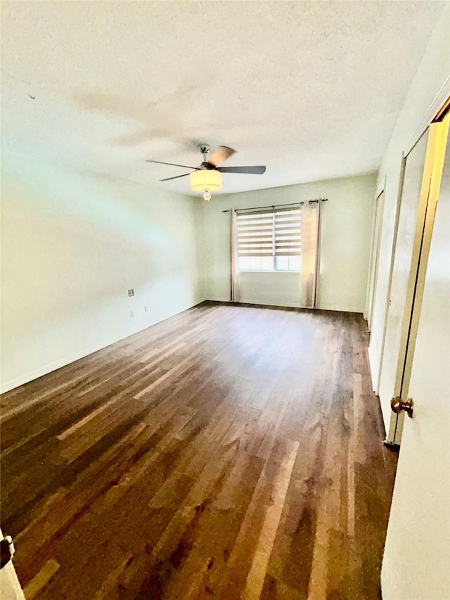 interior space with a ceiling fan, a textured ceiling, and wood finished floors