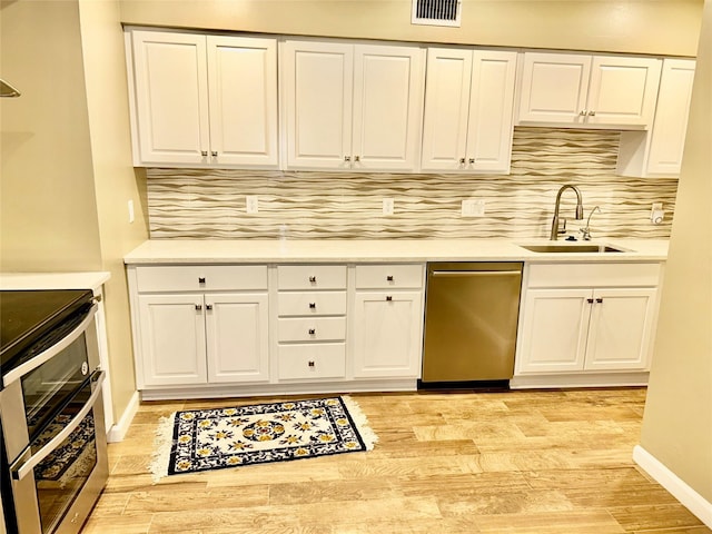 kitchen featuring visible vents, appliances with stainless steel finishes, light wood-style flooring, and a sink