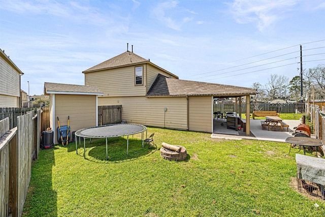 15307 Meandering Post Trl, Houston, TX 77044 - back of property with a trampoline, roof with shingles, a patio area, and a fire pit