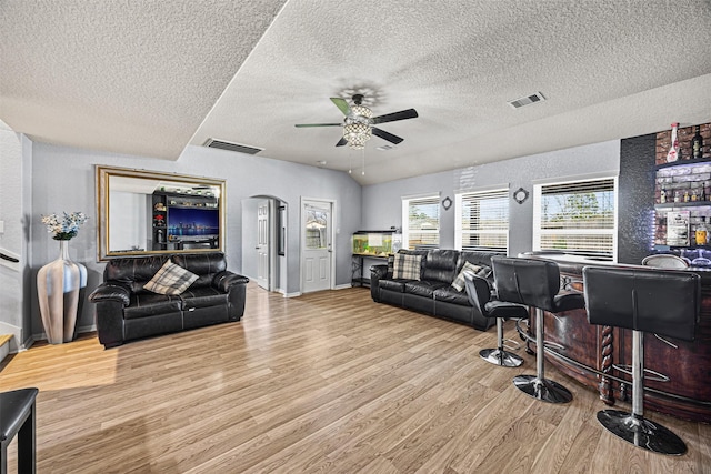 15307 Meandering Post Trl, Houston, TX 77044 - living area with wood finished floors, ceiling fan, a textured ceiling, baseboards, and arched walkways