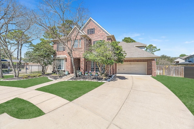 traditional home with driveway, a front lawn, fence, and brick siding