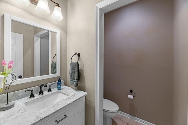 half bath featuring toilet, tile patterned flooring, baseboards, and vanity