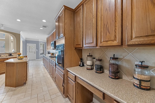 kitchen with arched walkways, brown cabinets, decorative backsplash, ornamental molding, and black oven