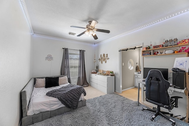 bedroom with light carpet, visible vents, and a ceiling fan