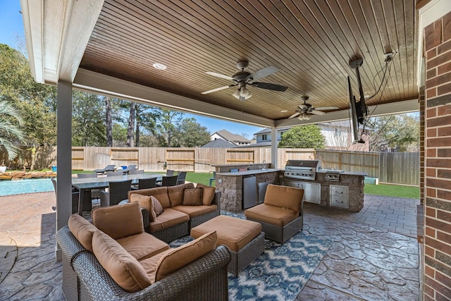 view of patio / terrace with a fenced backyard, grilling area, an outdoor hangout area, exterior kitchen, and outdoor dining space