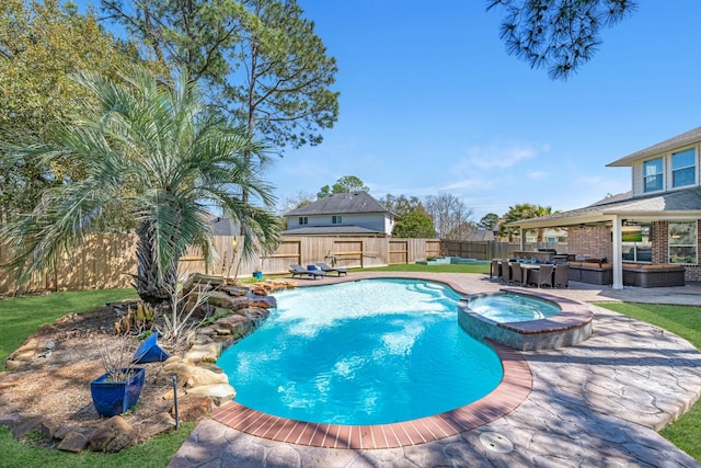 view of pool with a fenced backyard, a pool with connected hot tub, and a patio