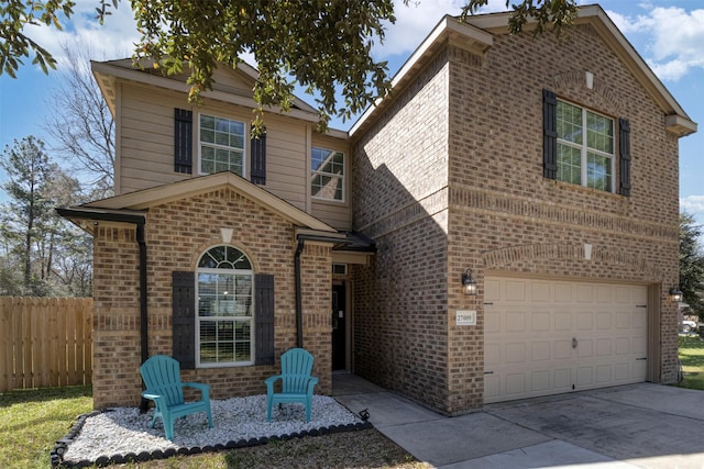 traditional-style home with driveway, brick siding, an attached garage, and fence