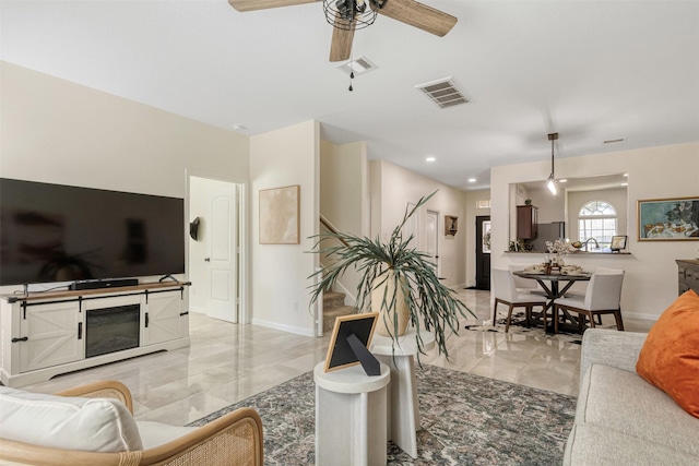 living area featuring marble finish floor, a ceiling fan, visible vents, and baseboards