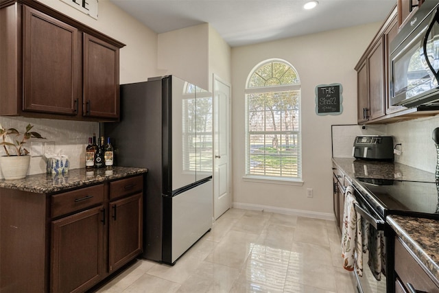 kitchen featuring tasteful backsplash, plenty of natural light, and black appliances