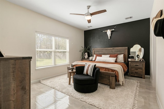 bedroom featuring baseboards, an accent wall, and visible vents