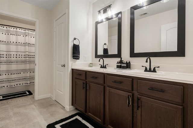 full bathroom featuring double vanity, tile patterned flooring, visible vents, and a sink