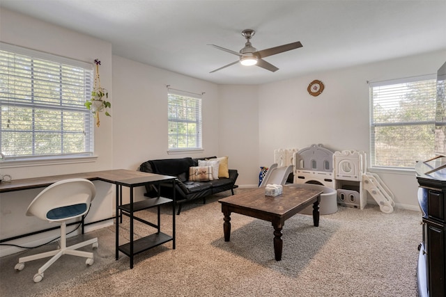 living room with ceiling fan, baseboards, and light colored carpet