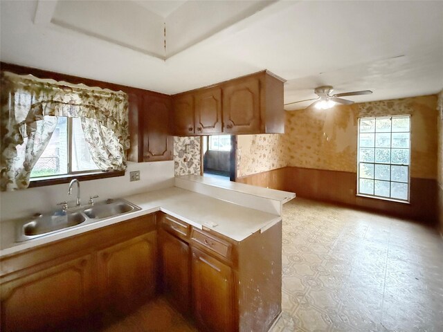 8611 Sunmoore Ct, Houston, TX 77088 - kitchen with wallpapered walls, plenty of natural light, wainscoting, a peninsula, and a sink