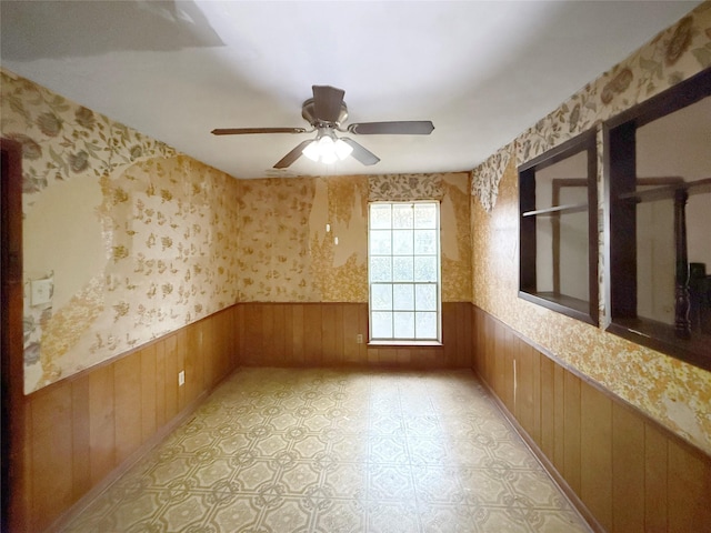 8611 Sunmoore Ct, Houston, TX 77088 - unfurnished room with wainscoting, ceiling fan, wood walls, and wallpapered walls