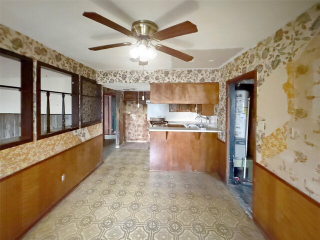 8611 Sunmoore Ct, Houston, TX 77088 - kitchen with a wainscoted wall, a peninsula, brown cabinets, and wallpapered walls