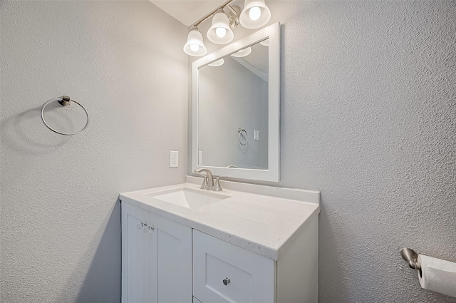 bathroom with a textured wall and vanity