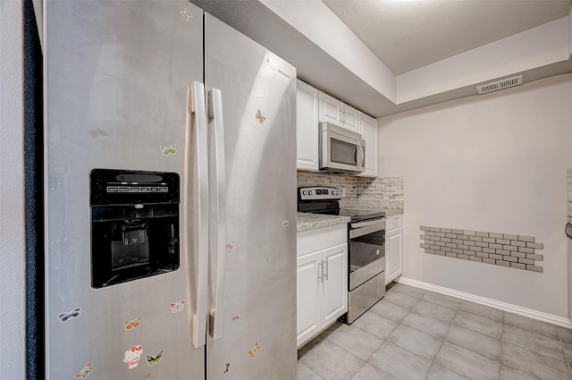 kitchen featuring light tile patterned floors, tasteful backsplash, visible vents, white cabinets, and stainless steel appliances