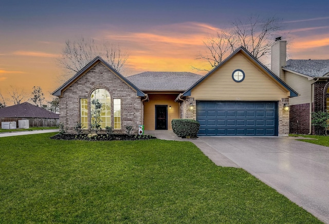 view of front of home with brick siding, roof with shingles, a front yard, a garage, and driveway