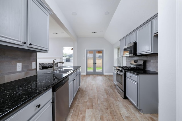 kitchen featuring french doors, light wood-style flooring, gray cabinetry, appliances with stainless steel finishes, and a sink