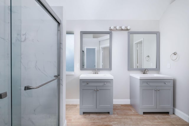 full bath featuring two vanities, a marble finish shower, and wood tiled floor