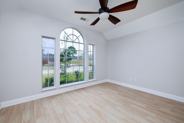 unfurnished room with visible vents, baseboards, a ceiling fan, wood finished floors, and vaulted ceiling