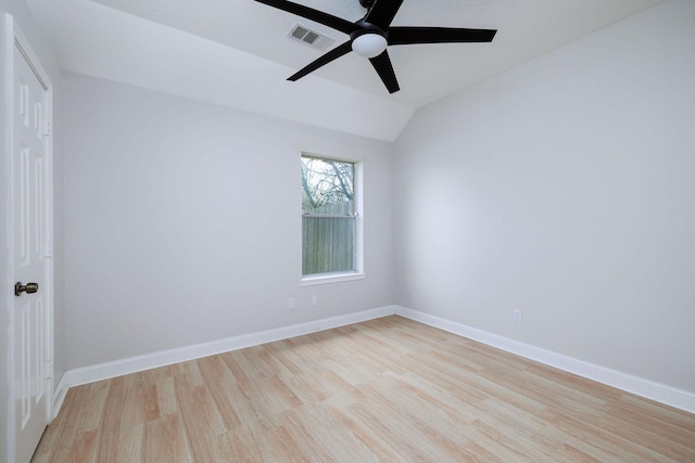 empty room featuring a ceiling fan, vaulted ceiling, light wood-style flooring, and baseboards