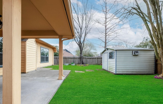 view of yard with a patio area, a fenced backyard, an outdoor structure, and a storage unit